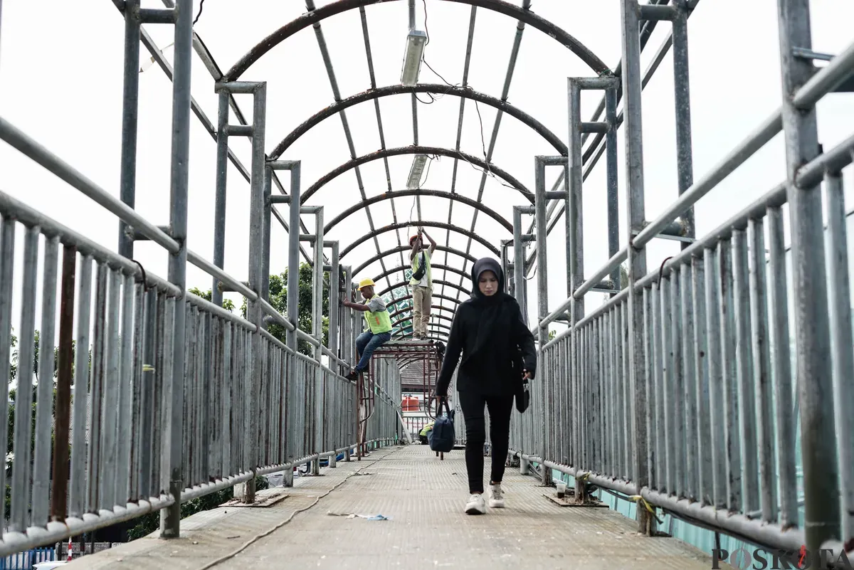 Petugas memperbaiki Jembatan Penyeberangan Orang (JPO) di Jalan Cempaka Putih, Jakarta, Rabu, 13 Agustus 2025. (Sumber: Poskota/Bilal Nugraha Ginanjar)