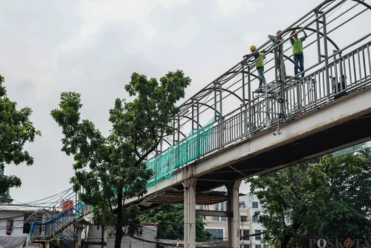 Petugas memperbaiki Jembatan Penyeberangan Orang (JPO) di Jalan Cempaka Putih, Jakarta, Rabu, 13 Agustus 2025. (Sumber: Poskota/Bilal Nugraha Ginanjar)