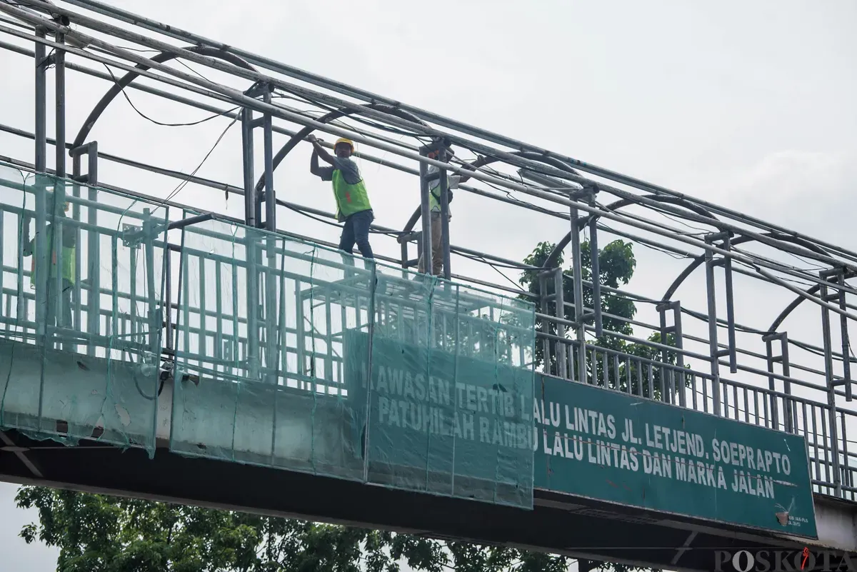 Petugas memperbaiki Jembatan Penyeberangan Orang (JPO) di Jalan Cempaka Putih, Jakarta, Rabu, 13 Agustus 2025. (Sumber: Poskota/Bilal Nugraha Ginanjar)