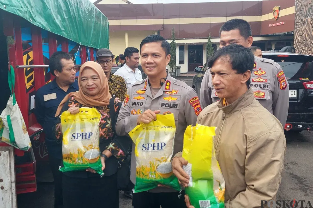 Kapolres Cimahi, AKBP Niko Nurallah Adi Putra (tengah) menunjukan beras murah dalam program Gerakan Pangan Murah di Mapolres Cimahi, Cigugur Tengah, Kec. Cimahi Tengah, Rabu, 14 Agustus 2025. (Sumber: Poskota/Gatot Poedji Utomo)