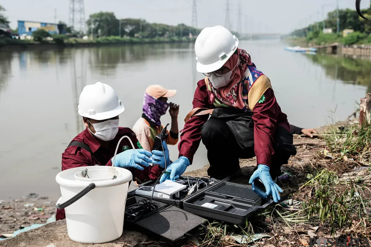 Petugas menyemprotkan air saat simulasi penanganan busa di Pintu Air Weir 3 Marunda, Kanal Banjir Timur (KBT), Jakarta Utara, Rabu, 13 Agustus 2025. (Sumber: Poskota/Bilal Nugraha Ginanjar)