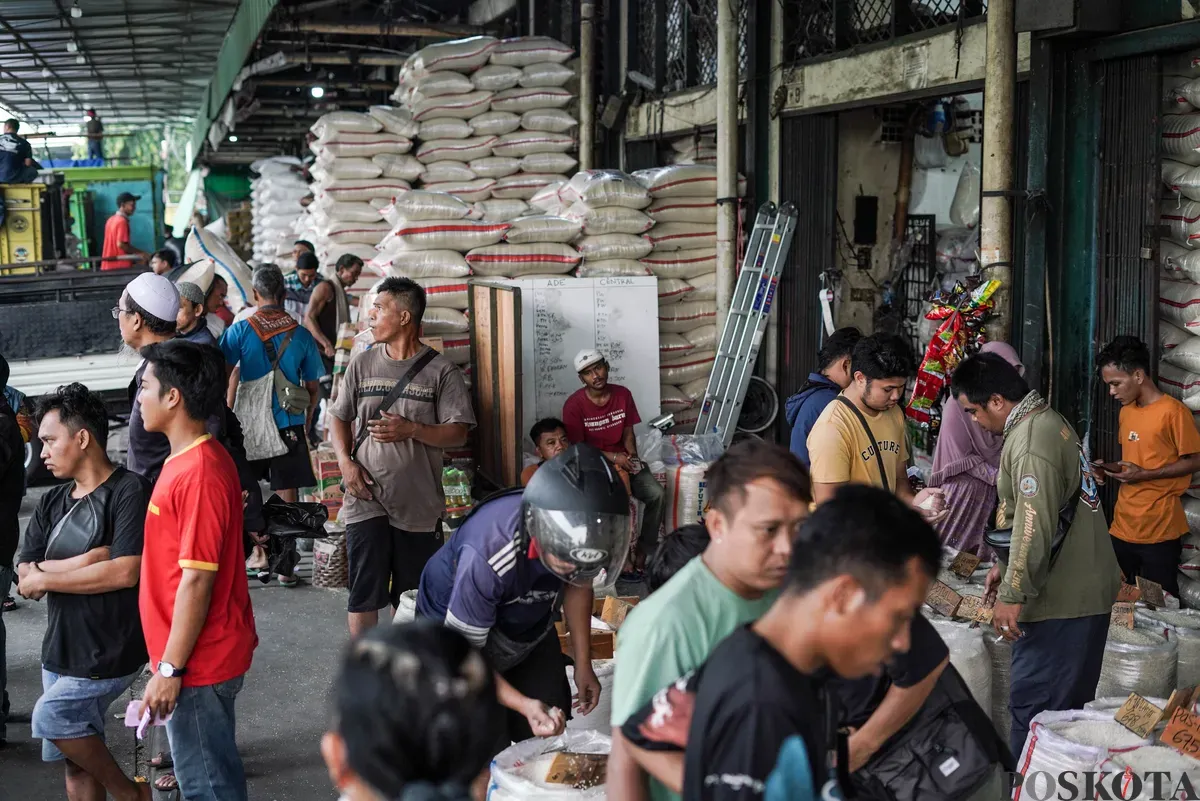 Buruh mengangkut beras di salah agen beras di Pasar Induk Beras Cipinang, Jakarta, Selasa, 12 Agustus, 2025. (Sumber: Poskota/Bilal Nugraha Ginanjar)
