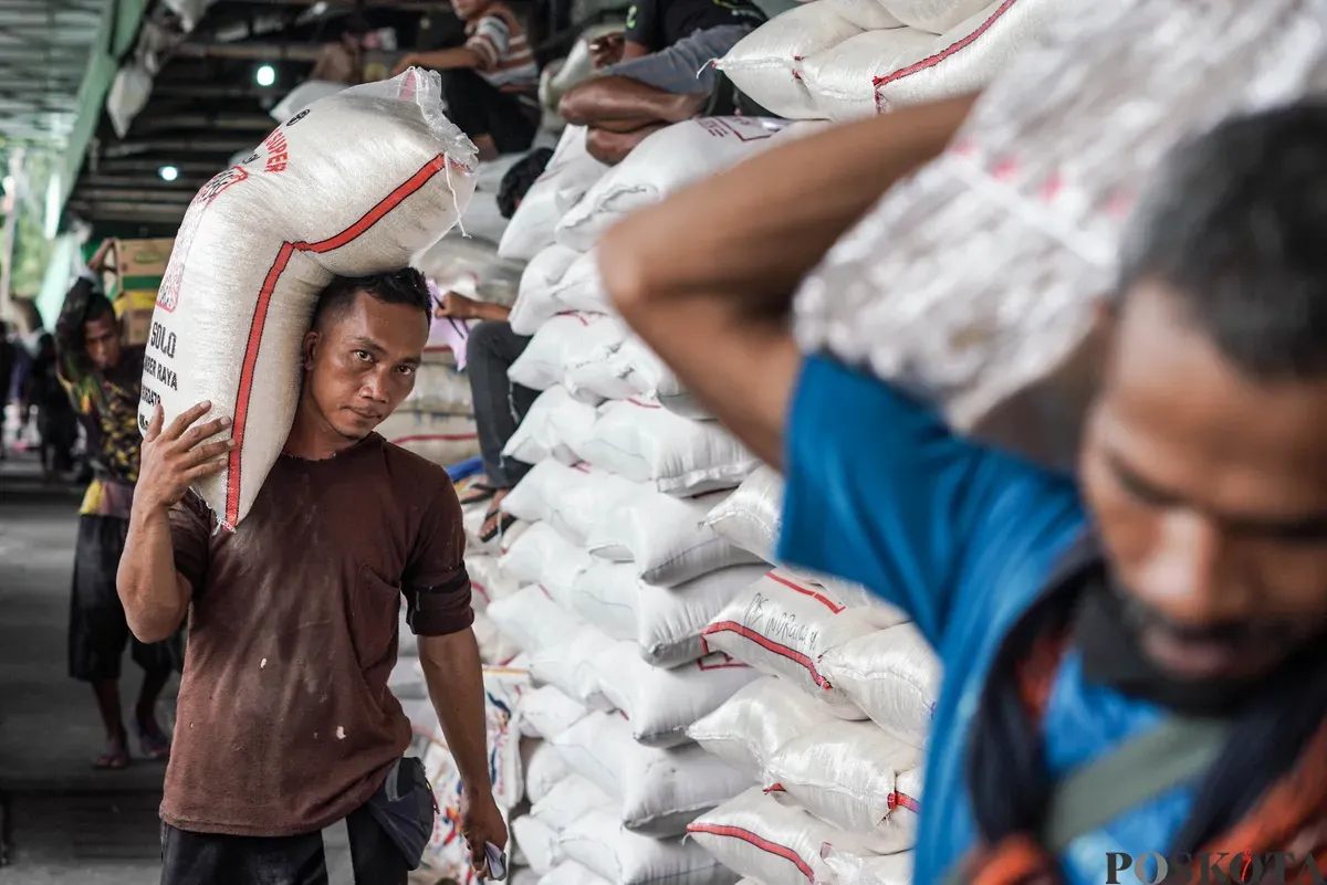 Buruh mengangkut beras di salah agen beras di Pasar Induk Beras Cipinang, Jakarta, Selasa, 12 Agustus, 2025. (Sumber: Poskota/Bilal Nugraha Ginanjar)
