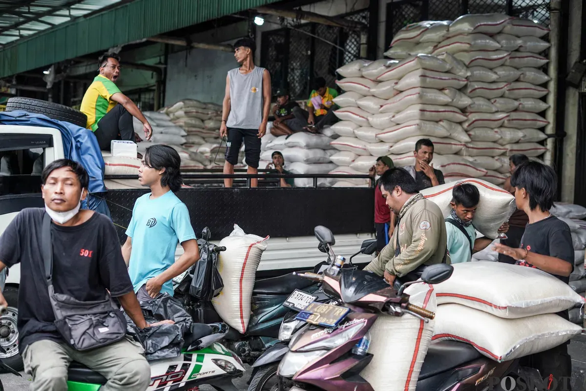 Buruh mengangkut beras di salah agen beras di Pasar Induk Beras Cipinang, Jakarta, Selasa, 12 Agustus, 2025. (Sumber: Poskota/Bilal Nugraha Ginanjar)