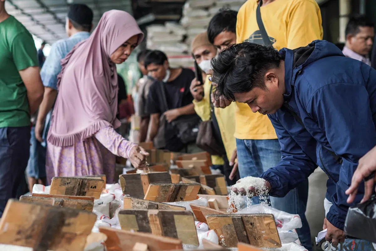 Buruh mengangkut beras di salah agen beras di Pasar Induk Beras Cipinang, Jakarta, Selasa, 12 Agustus, 2025. (Sumber: Poskota/Bilal Nugraha Ginanjar)