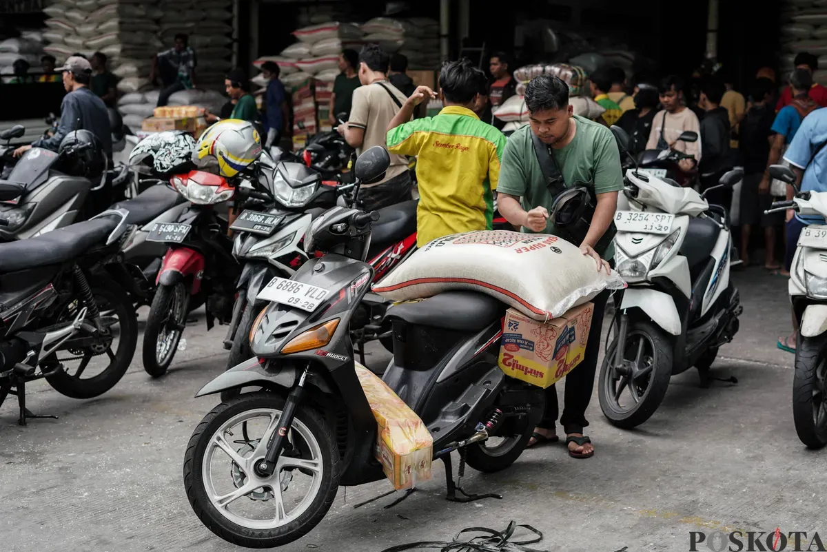 Buruh mengangkut beras di salah agen beras di Pasar Induk Beras Cipinang, Jakarta, Selasa, 12 Agustus, 2025. (Sumber: Poskota/Bilal Nugraha Ginanjar)