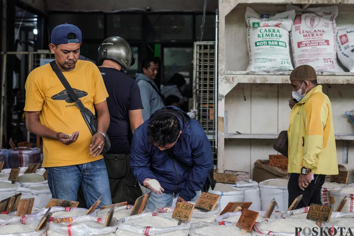 Buruh mengangkut beras di salah agen beras di Pasar Induk Beras Cipinang, Jakarta, Selasa, 12 Agustus, 2025. (Sumber: Poskota/Bilal Nugraha Ginanjar)