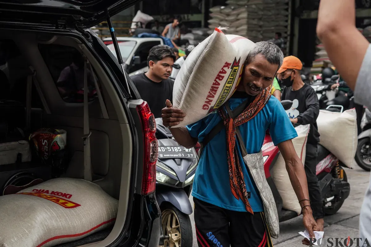 Buruh mengangkut beras di salah agen beras di Pasar Induk Beras Cipinang, Jakarta, Selasa, 12 Agustus, 2025. (Sumber: Poskota/Bilal Nugraha Ginanjar)