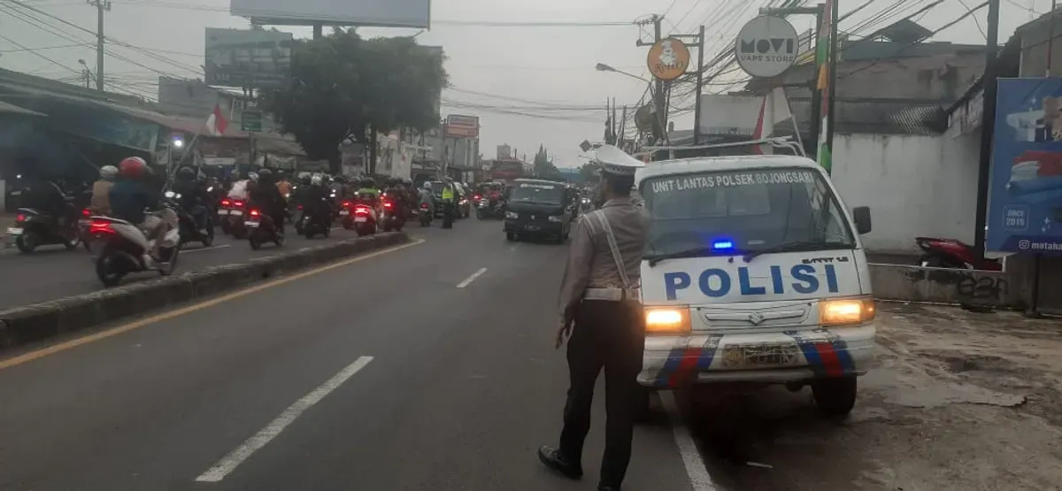 Petugas Polsek Bojongsari menempatkan kendaraan patroli dengan rotator biru menyala di jalur yang kerap dilalui pemotor melawan arus di Jalan Raya Parung–Ciputat, Kecamatan Bojongsari. (Sumber: Poskota/Angga Pahlevi)