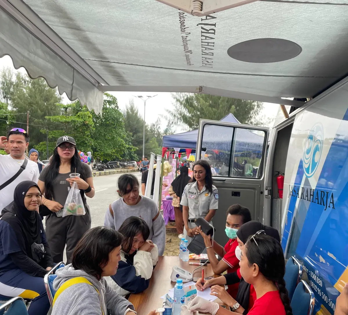 Petugas memberikan layanan kesehatan gratis kepada masyarakat dalam kegiatan sosialisasi pemutihan pajak kendaraan bermotor di Car Free Day Holtekamp, Kota Jayapura, Sabtu, 16 Agustus 2025. (Sumber: Ditlantas Polda Papua)