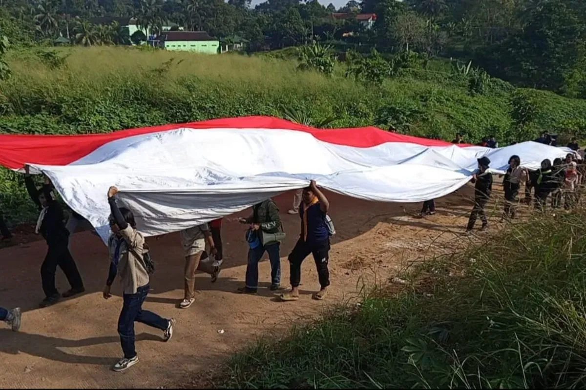 Puluhan Mapala saat membentangkan bendera Merah Pitih di kawasan TPA Bangkonol, Kecamatan Koroncong, Kabupaten Pandeglang, Minggu, 17 Agustus 2025. (Sumber: Dok. Mapala Banten)