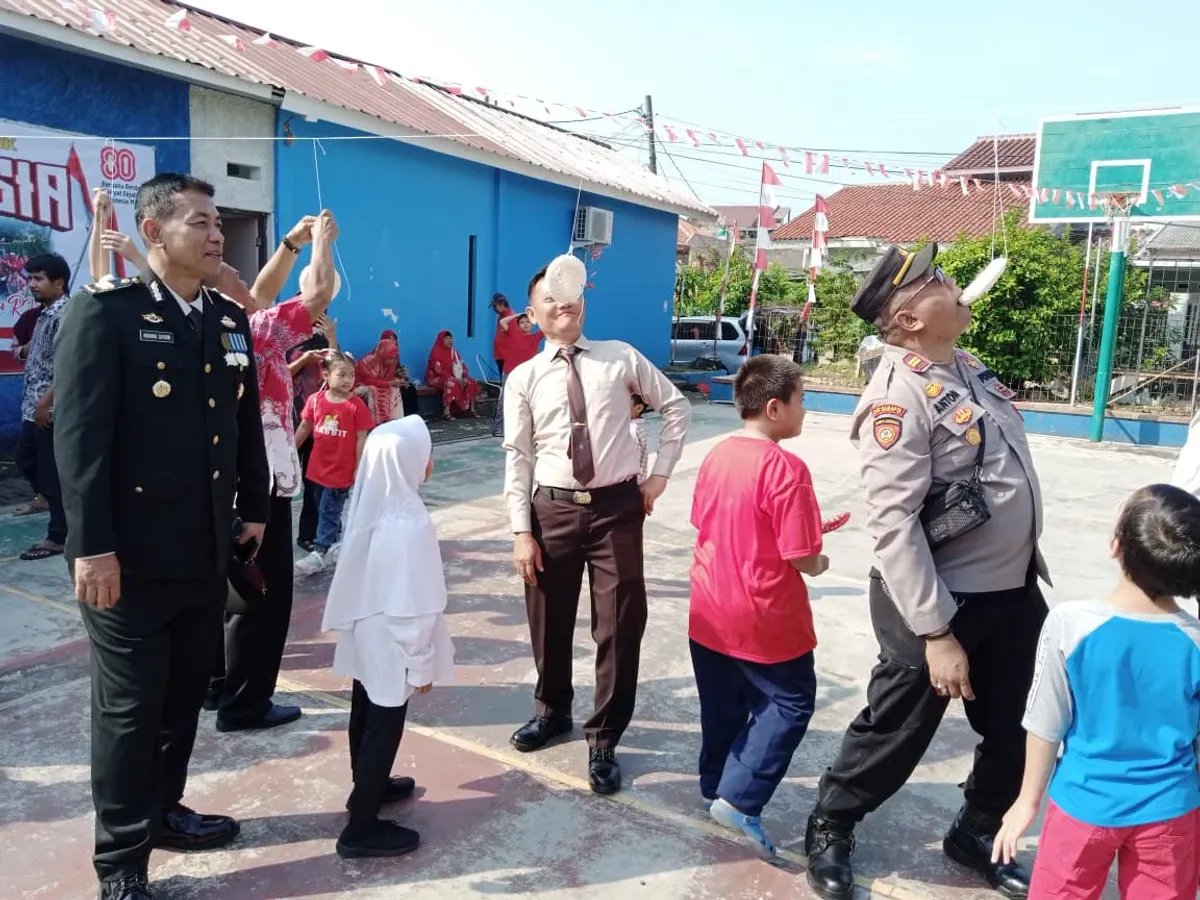 Kapolsek Pancoran Mas AKP Hartono bersama jajaran anggota Polsek ikut lomba makan kerupuk melawan warga RW 03. (Sumber: Polsek Pancoran Mas)