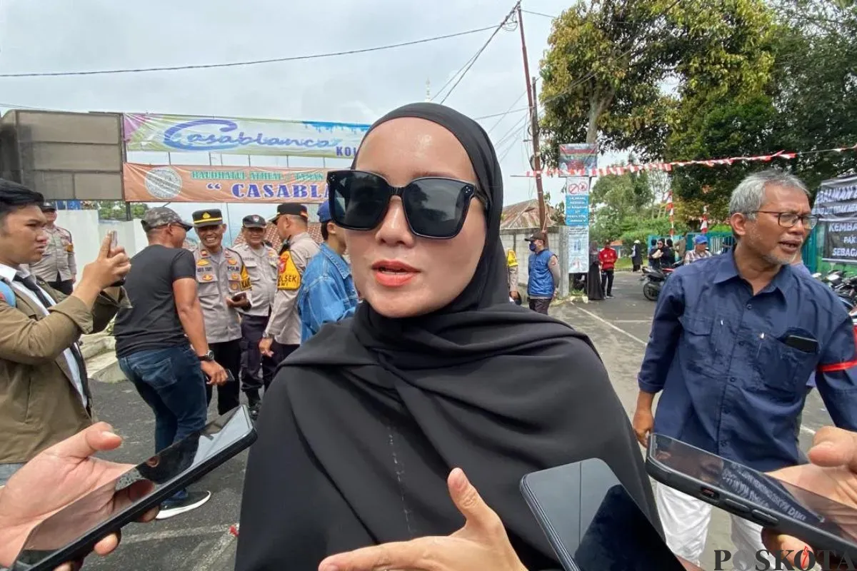 Orang tua murid, Hera 36 tahun, mengikuti aksi protes di depan gedung yayasan SDIT Raudlatul Jannah, Jalan Veteran III, Kecamatan Ciawi, Kabupaten Bogor, Selasa, 19 Agustus 2025. (Sumber: Poskota/Giffar Rivana)