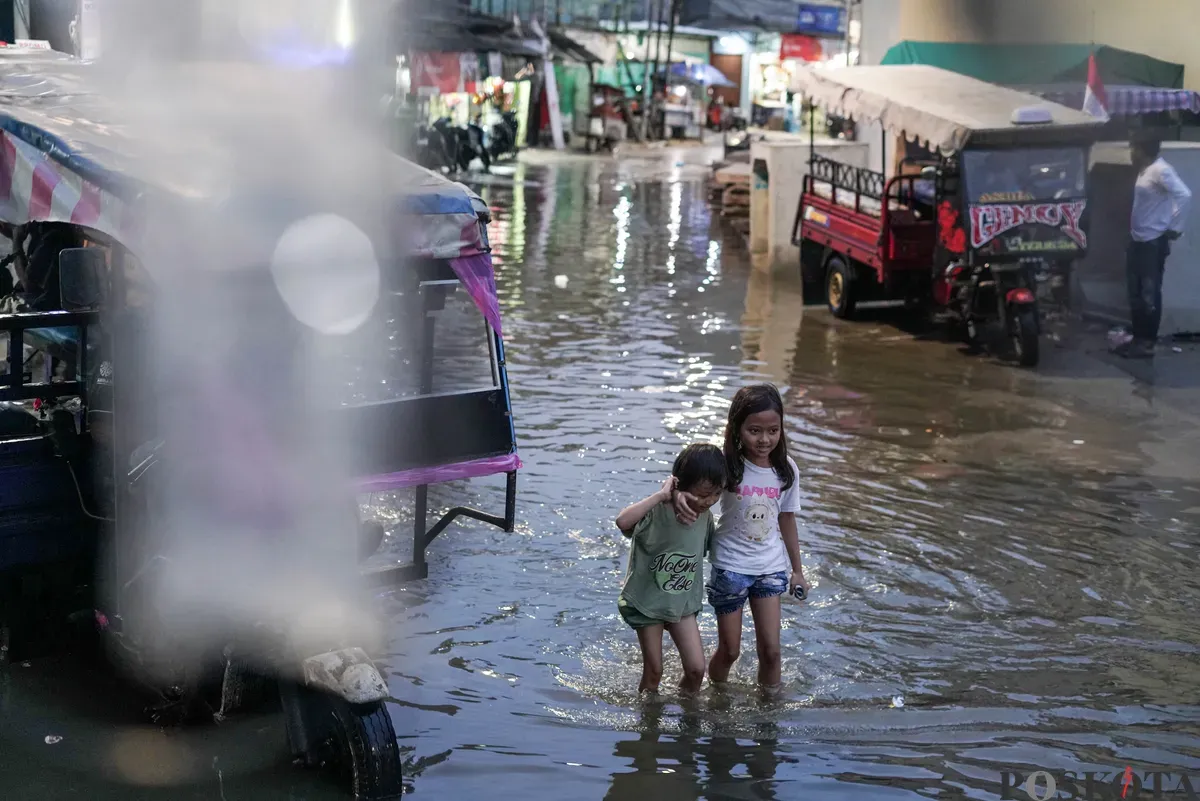 Warga melintasi genangan rob di Muara Angke, Jakarta Utara, Senin, 18 Agustus 2025. (Sumber: Poskota/Bilal Nugraha Ginanjar)
