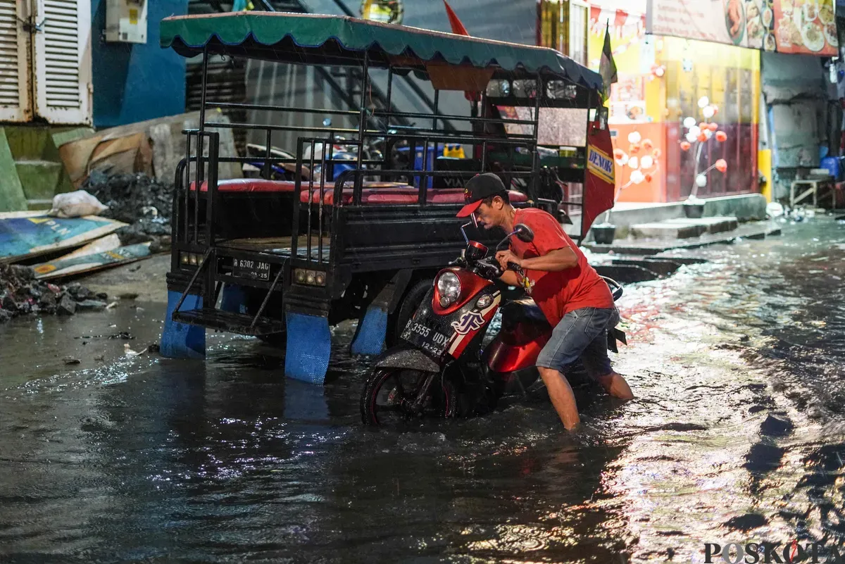 Warga melintasi genangan rob di Muara Angke, Jakarta Utara, Senin, 18 Agustus 2025. (Sumber: Poskota/Bilal Nugraha Ginanjar)