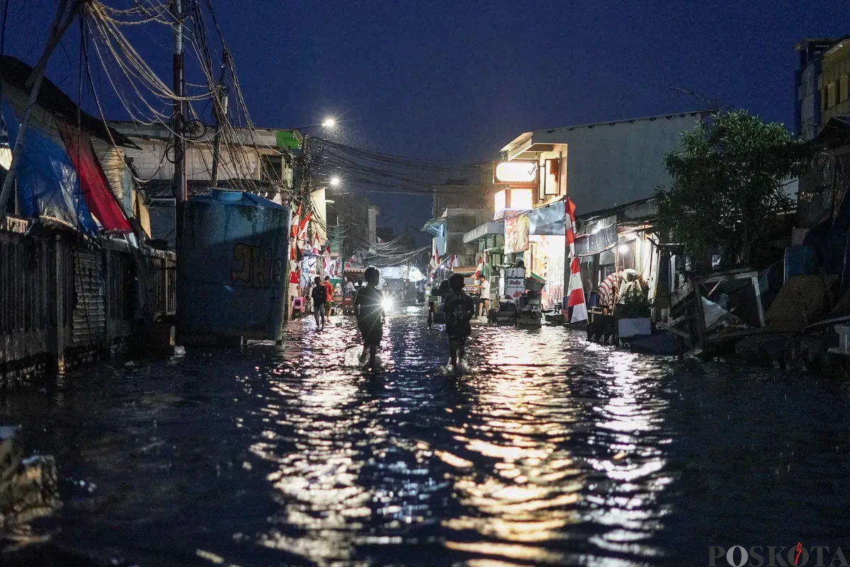 Warga melintasi genangan rob di Muara Angke, Jakarta Utara, Senin, 18 Agustus 2025. (Sumber: Poskota/Bilal Nugraha Ginanjar)