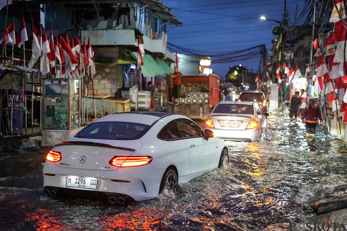 Warga melintasi genangan rob di Muara Angke, Jakarta Utara, Senin, 18 Agustus 2025. (Sumber: Poskota/Bilal Nugraha Ginanjar)