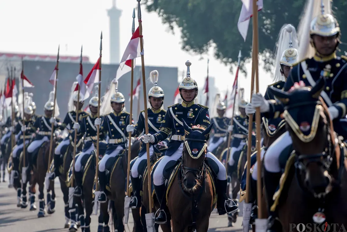 Purna Paskibraka Duta Pancasila 2024, Kirana Ashawidya Baskara dan Ni Komang Tri Setia membawa baki Bendera Pusaka Merah Putih dan Teks Proklamasi saat menaiki Kereta Kencana Garuda Prabayeksa pada Kirab Merah Putih HUT ke-80 Republik Indonesia di Monas, Jakarta, Minggu, 17 Agustus 2025 (Sumber: Poskota/Bilal Nugraha Ginanjar)