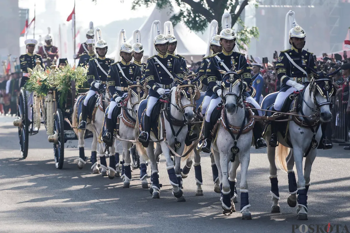 Purna Paskibraka Duta Pancasila 2024, Kirana Ashawidya Baskara dan Ni Komang Tri Setia membawa baki Bendera Pusaka Merah Putih dan Teks Proklamasi saat menaiki Kereta Kencana Garuda Prabayeksa pada Kirab Merah Putih HUT ke-80 Republik Indonesia di Monas, Jakarta, Minggu, 17 Agustus 2025 (Sumber: Poskota/Bilal Nugraha Ginanjar)