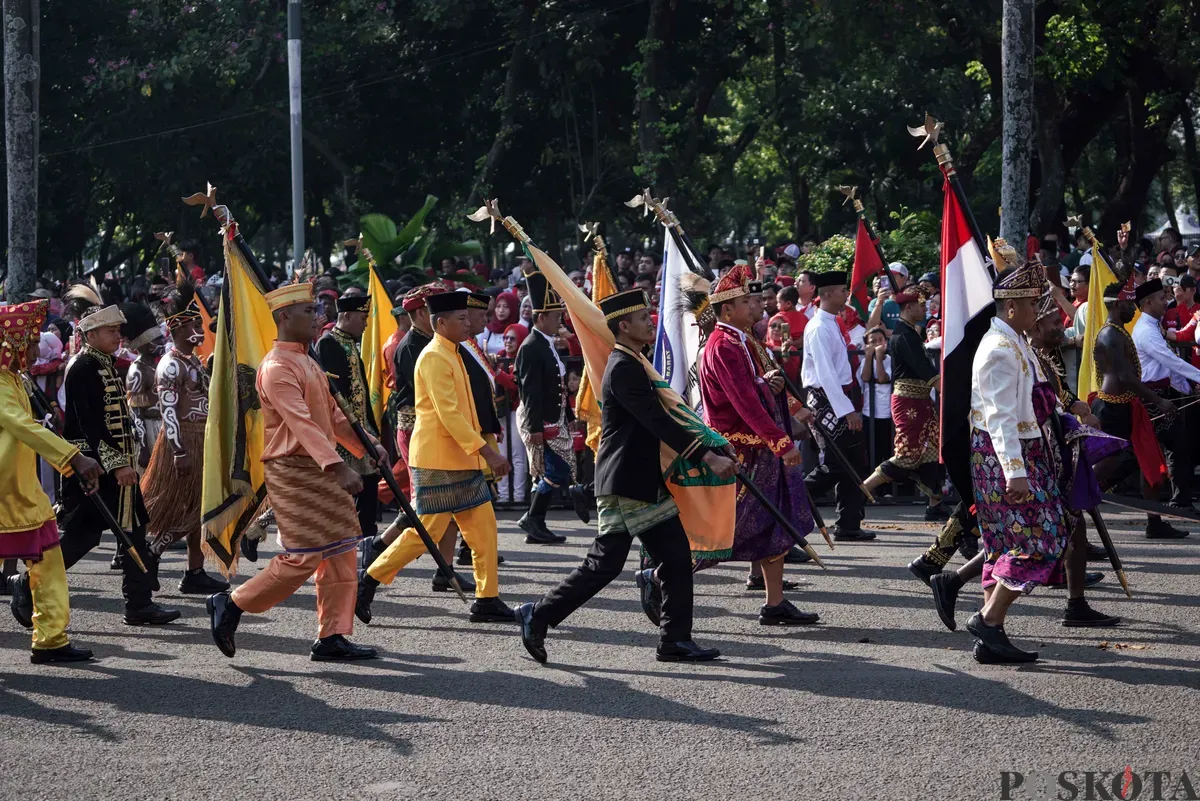 Purna Paskibraka Duta Pancasila 2024, Kirana Ashawidya Baskara dan Ni Komang Tri Setia membawa baki Bendera Pusaka Merah Putih dan Teks Proklamasi saat menaiki Kereta Kencana Garuda Prabayeksa pada Kirab Merah Putih HUT ke-80 Republik Indonesia di Monas, Jakarta, Minggu, 17 Agustus 2025 (Sumber: Poskota/Bilal Nugraha Ginanjar)