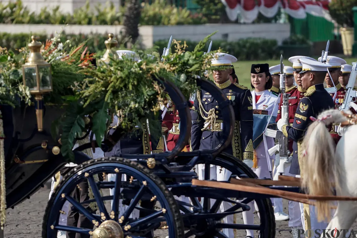 Purna Paskibraka Duta Pancasila 2024, Kirana Ashawidya Baskara dan Ni Komang Tri Setia membawa baki Bendera Pusaka Merah Putih dan Teks Proklamasi saat menaiki Kereta Kencana Garuda Prabayeksa pada Kirab Merah Putih HUT ke-80 Republik Indonesia di Monas, Jakarta, Minggu, 17 Agustus 2025 (Sumber: Poskota/Bilal Nugraha Ginanjar)