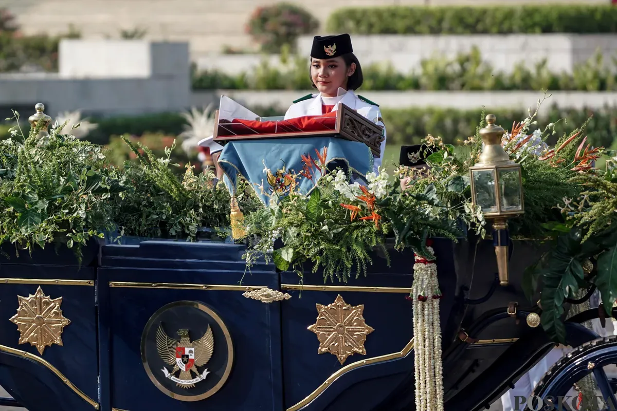 Purna Paskibraka Duta Pancasila 2024, Kirana Ashawidya Baskara dan Ni Komang Tri Setia membawa baki Bendera Pusaka Merah Putih dan Teks Proklamasi saat menaiki Kereta Kencana Garuda Prabayeksa pada Kirab Merah Putih HUT ke-80 Republik Indonesia di Monas, Jakarta, Minggu, 17 Agustus 2025 (Sumber: Poskota/Bilal Nugraha Ginanjar)