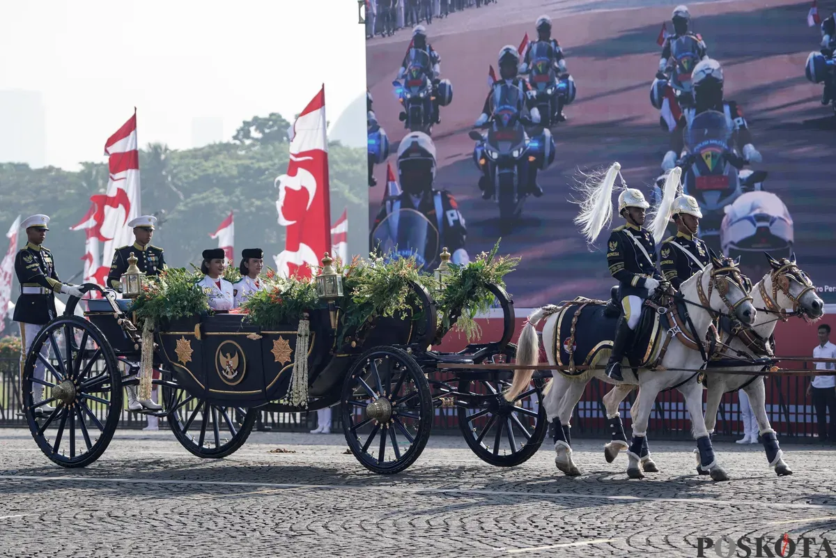 Purna Paskibraka Duta Pancasila 2024, Kirana Ashawidya Baskara dan Ni Komang Tri Setia membawa baki Bendera Pusaka Merah Putih dan Teks Proklamasi saat menaiki Kereta Kencana Garuda Prabayeksa pada Kirab Merah Putih HUT ke-80 Republik Indonesia di Monas, Jakarta, Minggu, 17 Agustus 2025 (Sumber: Poskota/Bilal Nugraha Ginanjar)
