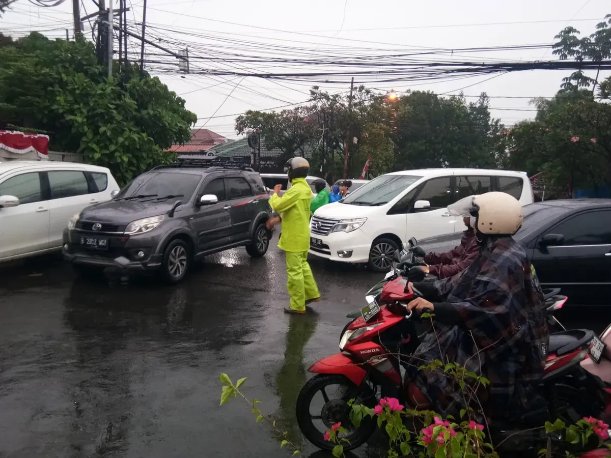 Ilustrasi - Polisi mengatur arus lalu lintas yang macet saat hujan deras. (Sumber: Polsek Cinere)