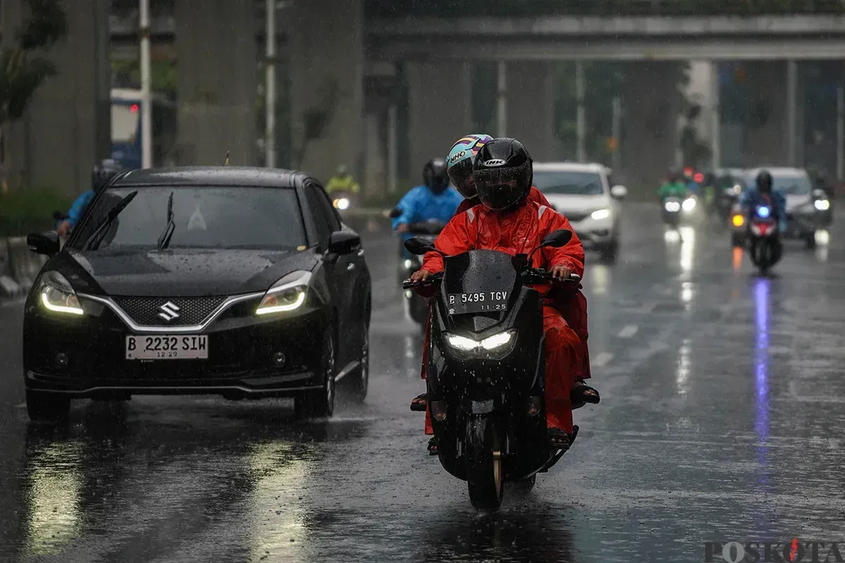 Pengendara motor mengenakan jas hujan saat melintasi jalan ibu kota di tengah hujan deras. Pemprov Jakarta bersama BPBD memperkuat langkah mitigasi menghadapi musim penghujan. (Sumber: Poskota/Bilal Nugraha Ginanjar)