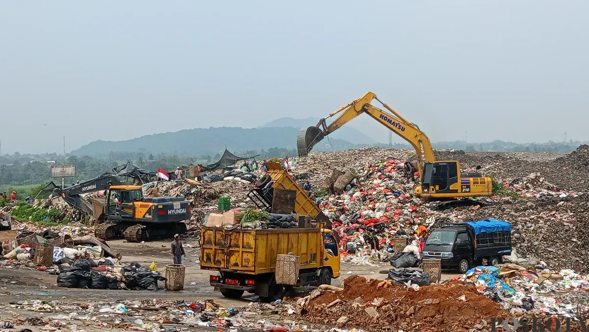 Alat berat menguruk gunungan sampah di TPAS Galuga, Kecamatan Cibungbulang, Kabupaten Bogor. Pemkab Bogor mengajukan anggaran Rp17 miliar untuk modernisasi pengelolaan sampah di lokasi ini. (Sumber: Poskota/Giffar Rivana)