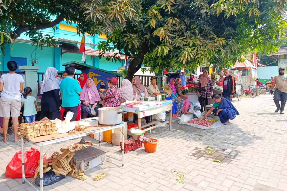 Pedagang Pasar Pejuang Pratama, Medan Satria, Kota Bekasi, terpaksa menggelar lapak darurat di depan kios mereka yang ludes dilalap api pada Sabtu, 23 Agustus 2025 malam. (Sumber: Poskota/Nurpini Aulia Rapika)