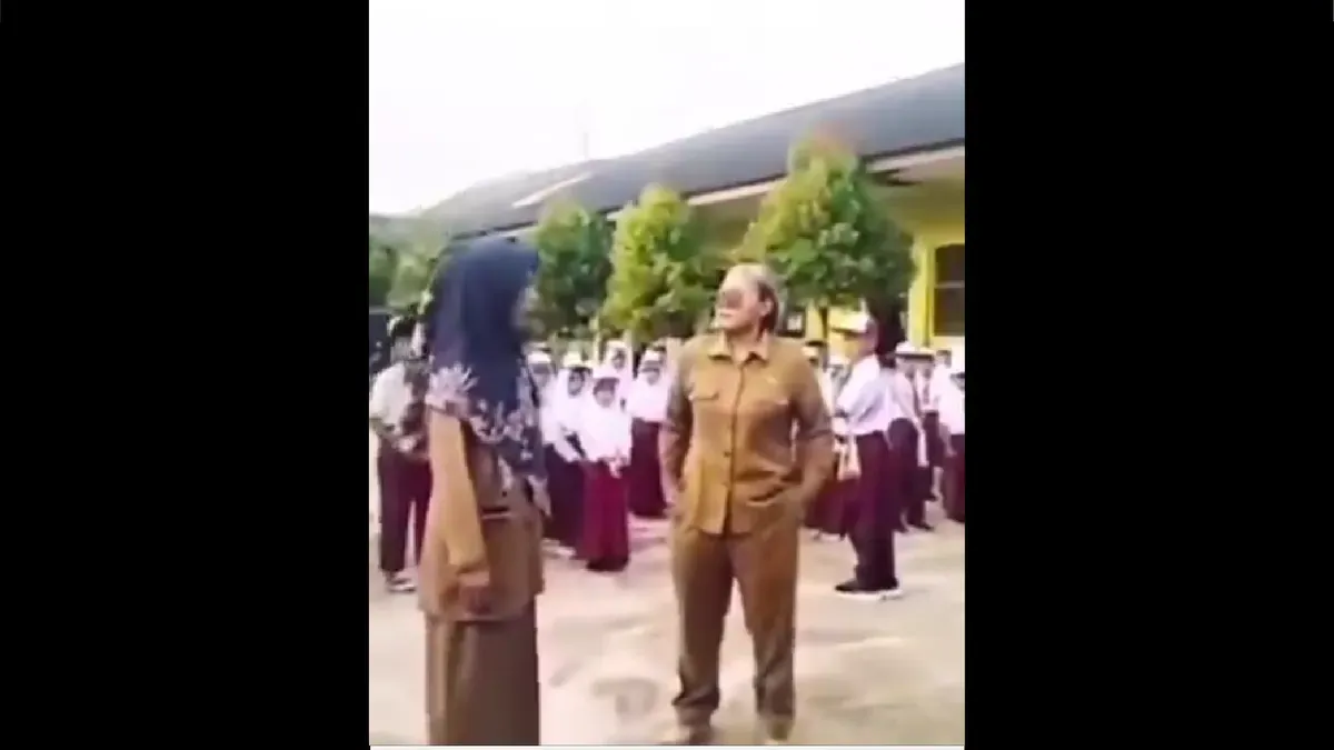 Viral video memperlihatkan guru perempuan berseragam ASN yang diduga melakukan intimidasi terhadap guru lain dan siswa saat upacara bendera di SDN 9 Kedondong, Kabupaten Pesawaran, Lampung. (Sumber: X/@B3doel___)