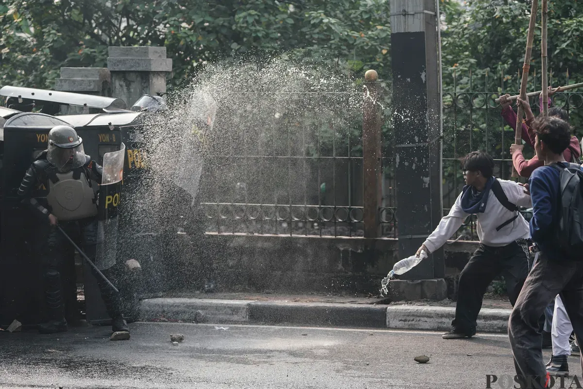 Sejumlah massa aksi berhadapan dengan aparat saat demo di belakang DPR dan Pejompongan, Jakarta, Senin, 25 Agustus 2025. (Sumber: Poskota/Bilal Nugraha Ginanjar)