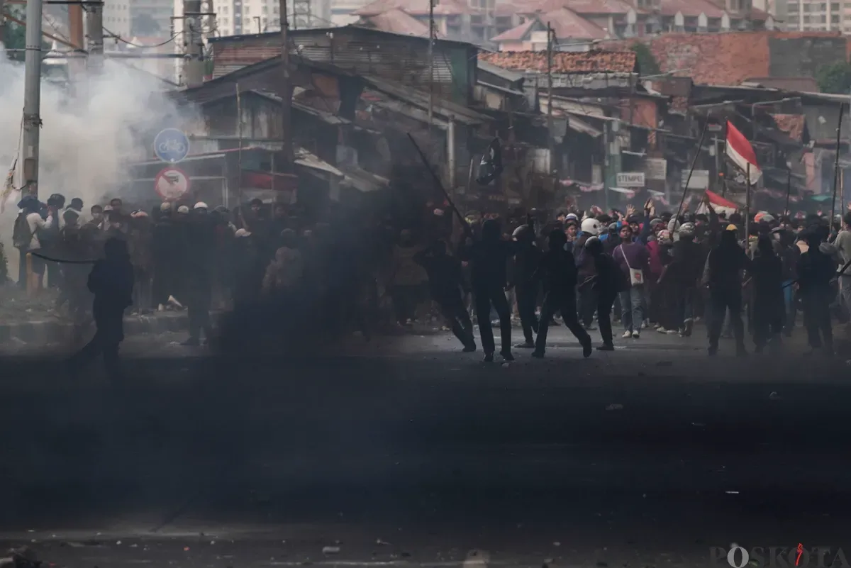 Sejumlah massa aksi berhadapan dengan aparat saat demo di belakang DPR dan Pejompongan, Jakarta, Senin, 25 Agustus 2025. (Sumber: Poskota/Bilal Nugraha Ginanjar)