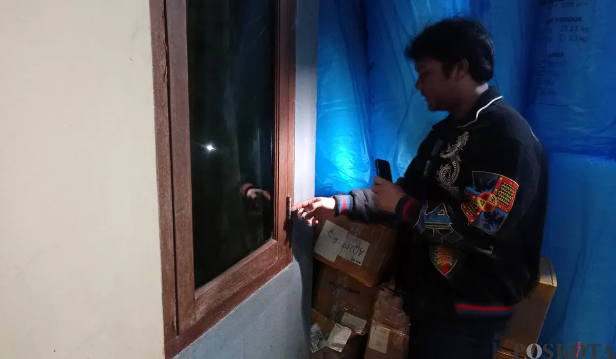 Pegawai toko online, Aldo, menunjukkan jendela yang dirusak maling untuk melancarkan malingnya, Senin 25 Agustus 2025. (Sumber: POSKOTA | Foto: Giffar Rivana)