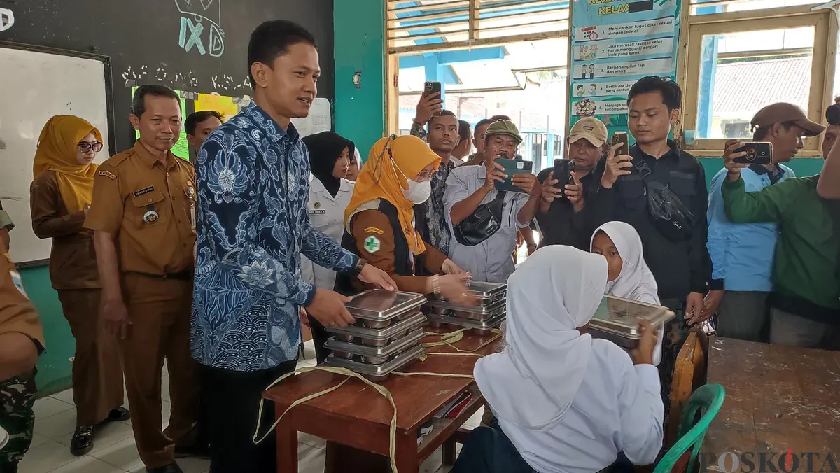 Wakil Bupati Pandeglang saat membagikan paket MBG kepada para siswa SMPN 1 Labuan. (Sumber: Poskota/Samsul Fatoni)