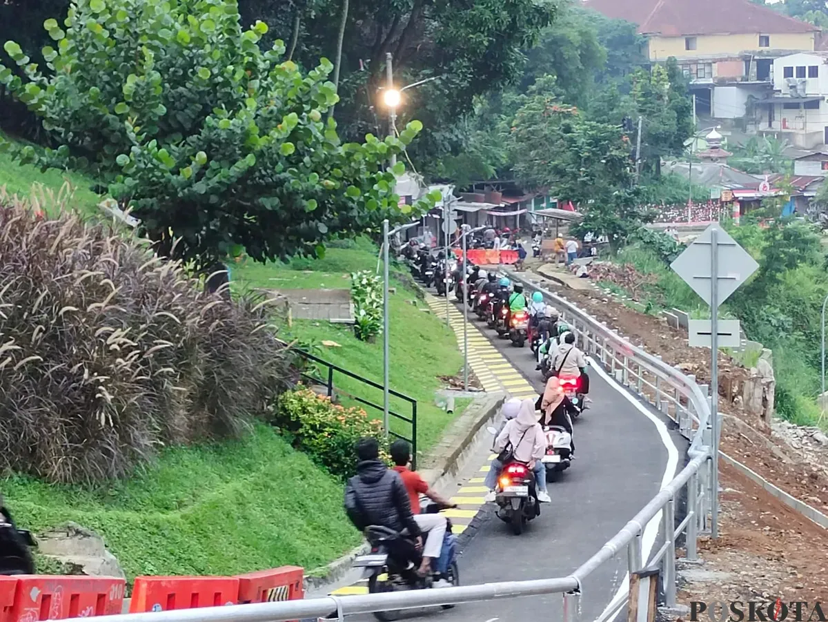 Warga melintas Jalan Saleh Danasasmita, Batutulis, Kota Bogor usai diperbaiki pasca longsor yang terjadi pada Maret lalu. (Sumber: Poskota/Giffar Rivana)