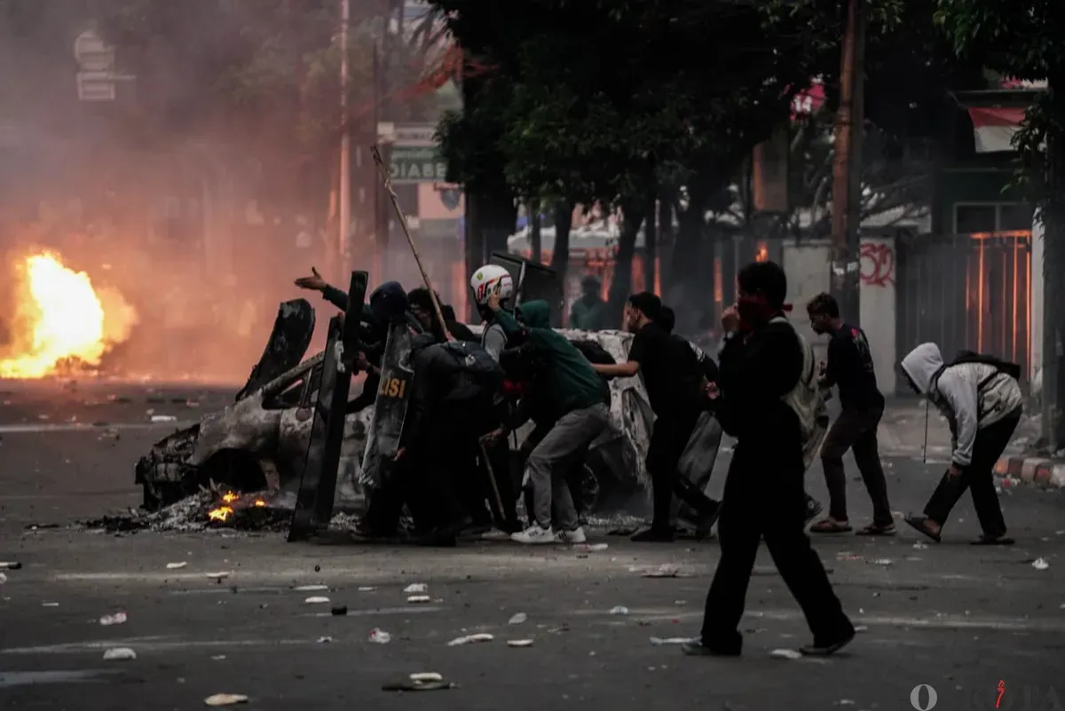 Massa aksi berlindung di balik tameng saat bentrok dengan pihak keamanan di Satuan Brimob Polda Metro Jaya, Kecamatan Senen, Jakarta Pusat, Jumat, 29 Agustus 2025. (Sumber: Poskota/Bilal Nugraha Ginanjar)