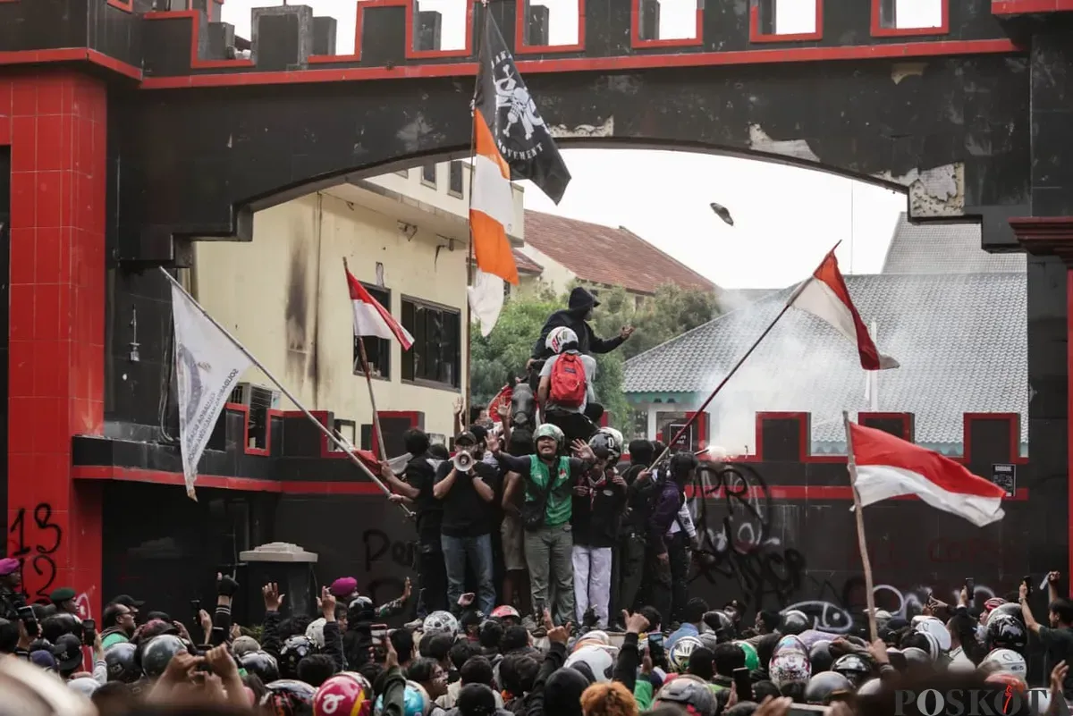 Demonstran beratribut ojol terlihat menenangkan massa aksi saat unjuk rasa di depan Satuan Brimob Polda Metro Jaya, Kecamatan Senen, Jakarta Pusat, Jumat, 29 Agustus 2025. (Sumber: Poskota/Bilal Nugraha Ginanjar)