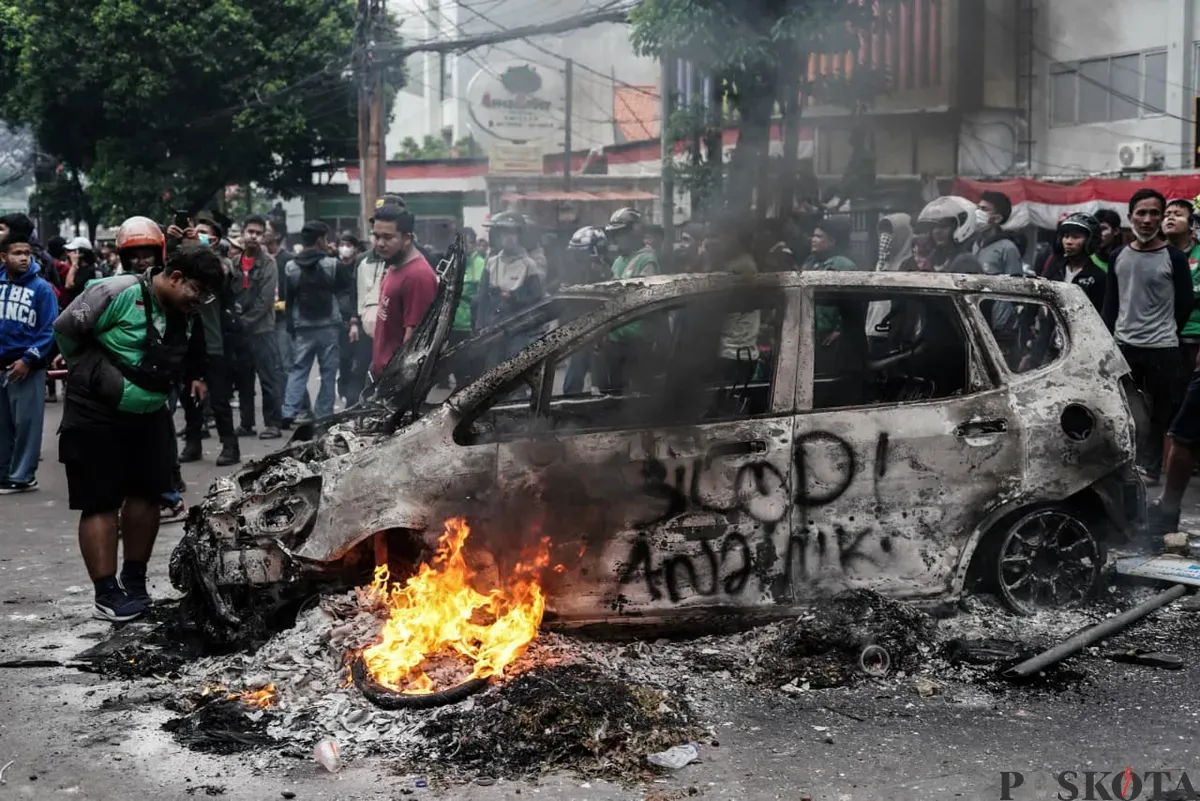 Mobil hangus terbakar saat demonstrasi di depan Satuan Brimob Polda Metro Jaya, Kecamatan Senen, Jakarta Pusat, Jumat, 29 Agustus 2025. (Sumber: Poskota/Bilal Nugraha Ginanjar)