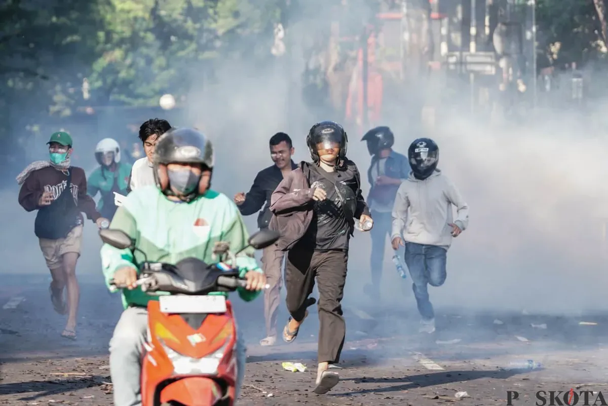 Massa aksi terlihat berlarian saat demonstrasi di Mako Brimob Polda Metro Jaya, Kwitang, Jakarta Pusat, Jumat, 29 Agustus 2025. (Sumber: Poskota/Bilal Nugraha Ginanjar)