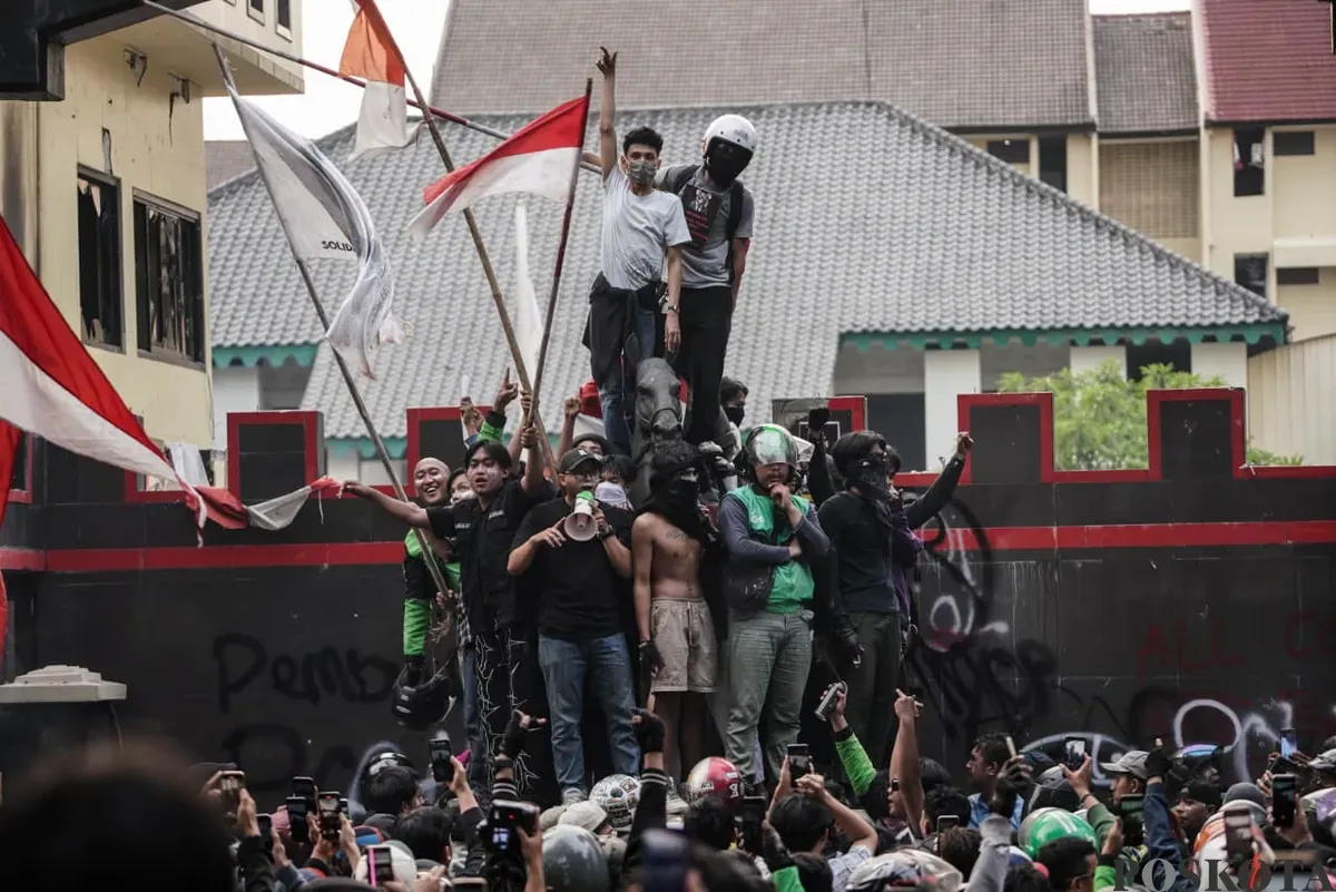 Beberapa massa aksi naik ke atas patung Komjen (Purn) Dr. H. Moehammad Jasin di Marko Brimob Polda Metro Jaya, Kecamatan Senen, Jakarta Pusat, Jumat, 29 Agustus 2025. (Sumber: Poskota/Bilal Nugraha Ginanjar)