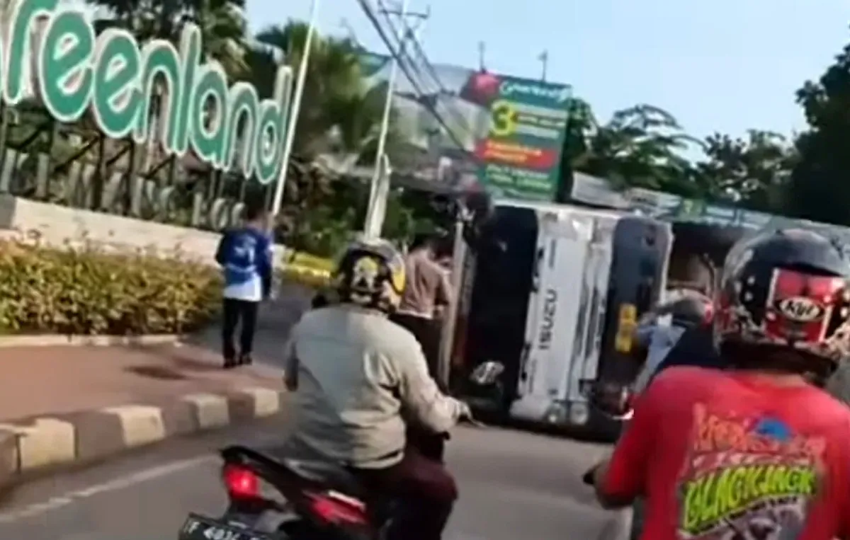 Tangkap layar truk tronton pembawa batu kerikil terbalik di Jalan Raya Parung, Kecamatan Kemang, Kabupaten Bogor.