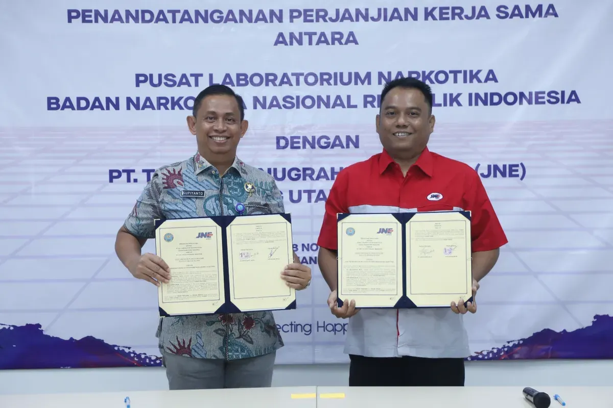 Kepala Pusat Laboratorium Narkotika BNN Supiyanto dan Kepala Cabang JNE Bogor Ade Kurniawan menunjukkan dokumen Perjanjian Kerja Sama yang baru ditandatangani di Bogor. (Sumber: Biro Humas dan Protokol BNN)
