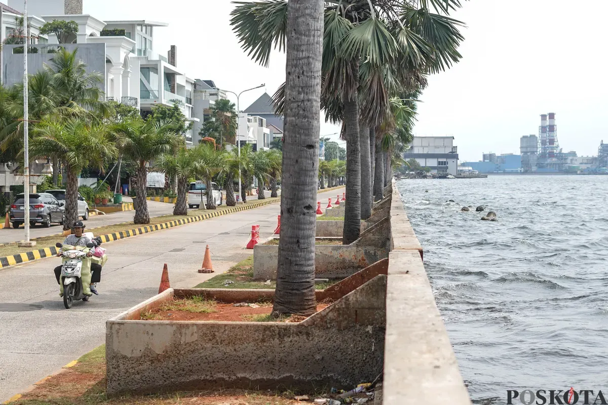 Pengendara sepeda motor melintas di samping tanggul Pantai Mutiara, Penjaringan, Jakarta Utara, Senin, 1 Desember 2025. (Sumber: Poskota/Bilal Nugraha Ginanjar)