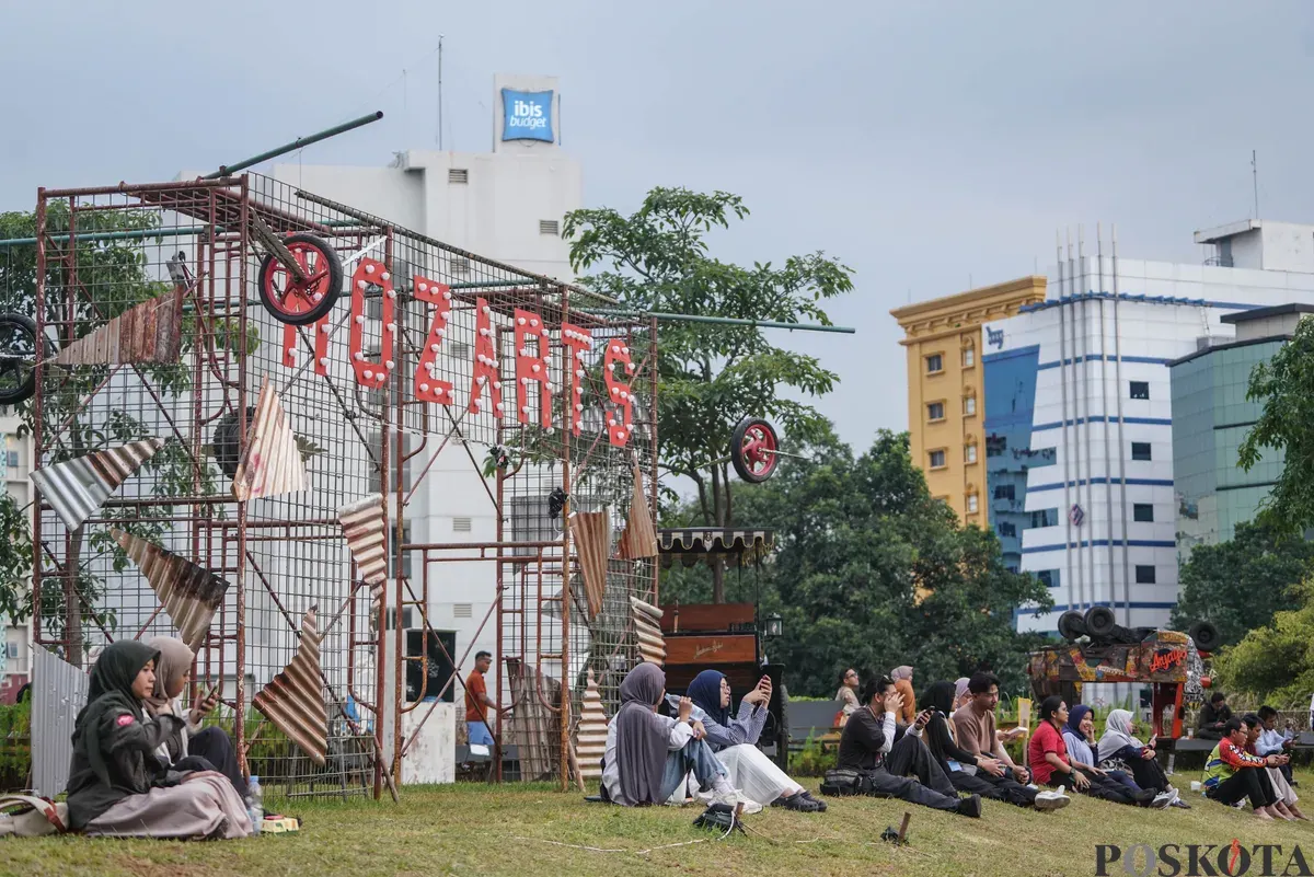 Sejumlah pengunjung melihat karya dalam Pameran Seni Rupa Motorsaikel Kalcer: Gas Aja Dulu yang digelar di Rooftop Garden Plaza Taman Ismail Marzuki (TIM), Jalan Cikini Raya, Menteng, Jakarta, Kamis, 27 November 2025. (Sumber: Poskota/Bilal Nugraha Ginanjar)