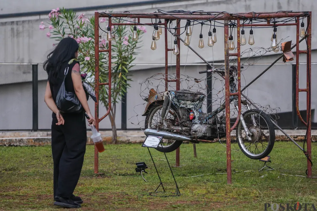 Sejumlah pengunjung melihat karya dalam Pameran Seni Rupa Motorsaikel Kalcer: Gas Aja Dulu yang digelar di Rooftop Garden Plaza Taman Ismail Marzuki (TIM), Jalan Cikini Raya, Menteng, Jakarta, Kamis, 27 November 2025. (Sumber: Poskota/Bilal Nugraha Ginanjar)