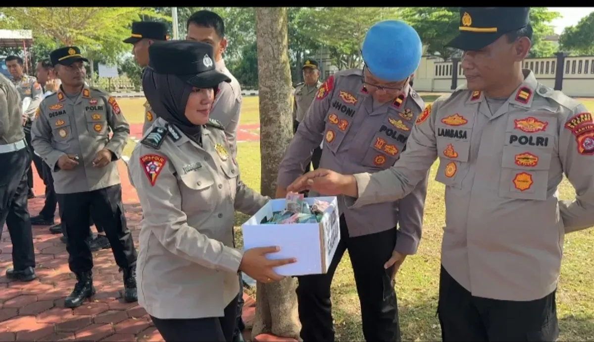 Satu petugas tengah mengumpulkan dana peduli bencana usai apel pagi di Mapolres Serang. (Sumber: Humas Polres Serang)