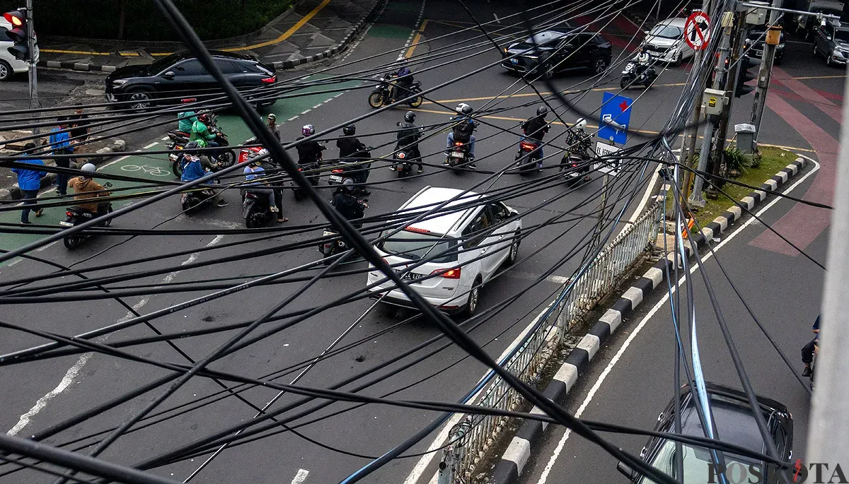 Kondisi kabel udara yang semerawut di perempatan lampu merah Jalan Dewi Sartika, Jakarta Timur, pada Selasa, 2 Desember 2025. (Sumber: POSKOTA | Foto: Dhiya Ahmad Fauzan/M2)