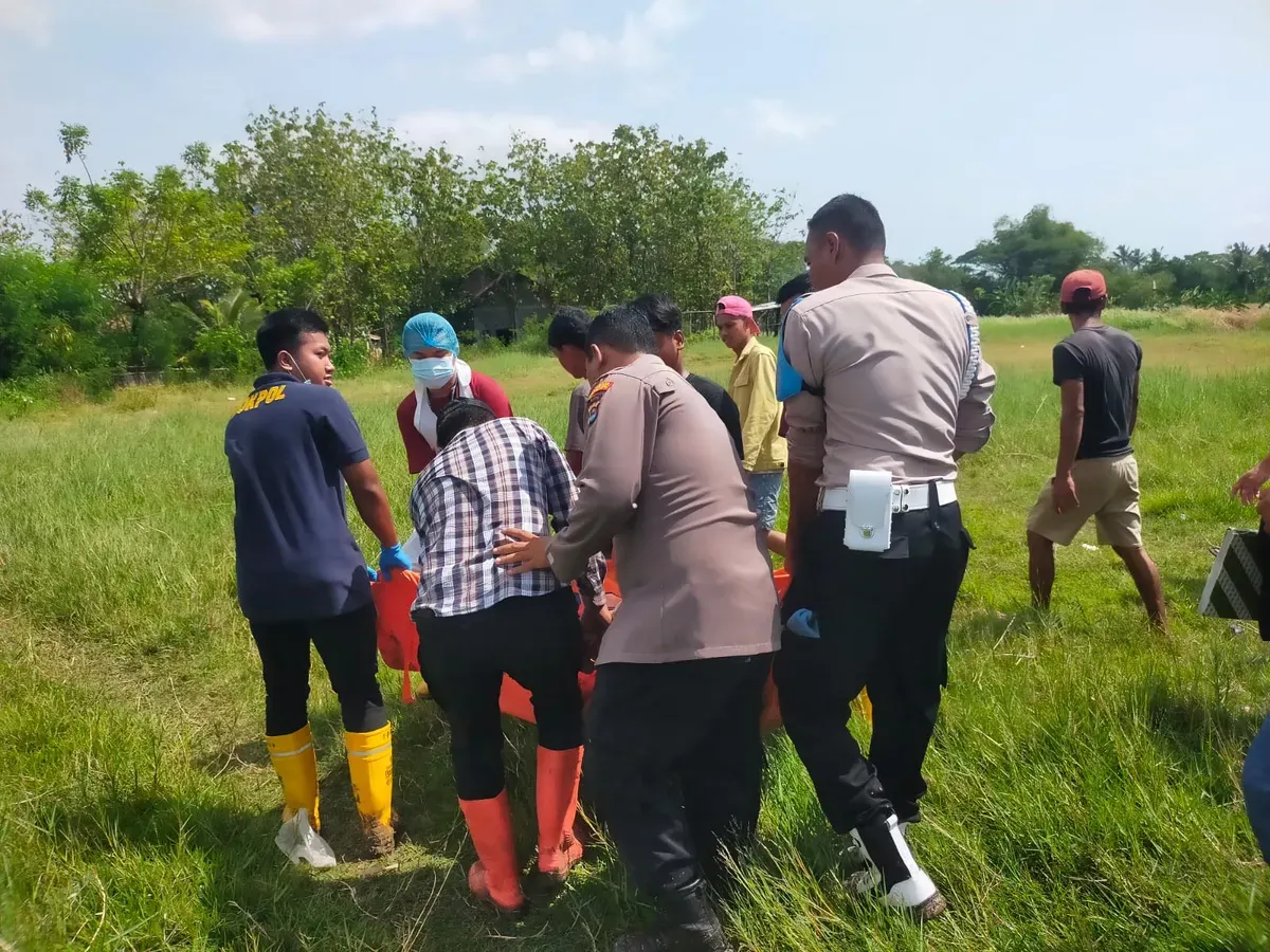 Petugas Polsek Kasemen bersama warga mengevakuasi korban meninggal setelah tersambar petir. (Sumber: Dok. Humas Polresta Serang Kota)